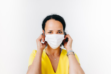 black woman putting on a surgical mask