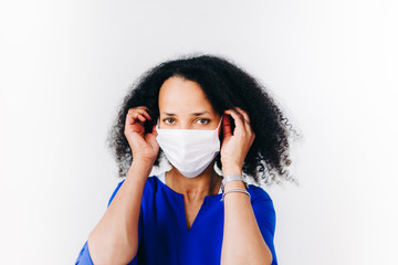 black woman putting on a surgical mask