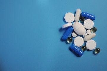 Many anti-viral drugs on blue table. Medicine against COVID-19 and diseases