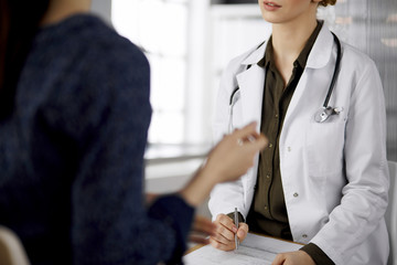 Doctor and patient discussing current health examination while sitting in clinic. Perfect medical...