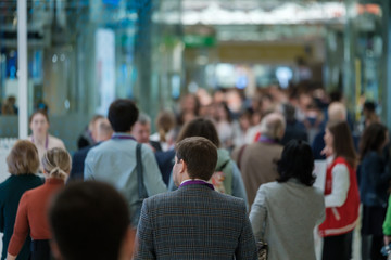 Crowd of people walking indoors, defocused,