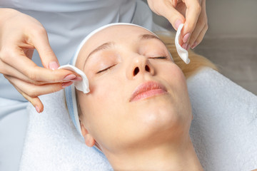 Obraz na płótnie Canvas Close-up beautician doctor hand making anti-age procedure, mask and peeling for young attractive female client at beauty clinic. Cosmetologist specialist doing skincare treatment .Health care therapy