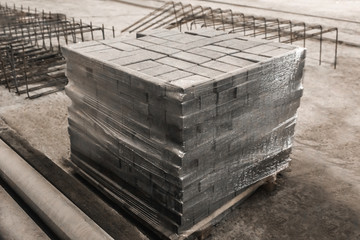 Concrete blocks packed in cellophane film at a construction site. Concrete bricks in an industrial area