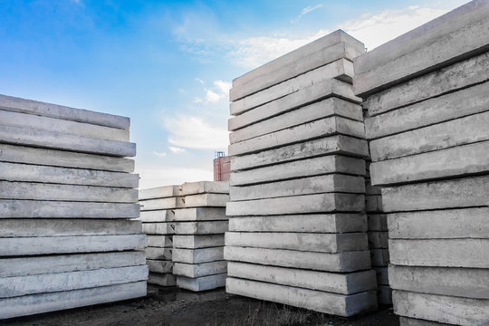 Concrete blocks at a construction site. Concrete structures in an industrial area against a blue sky with clouds