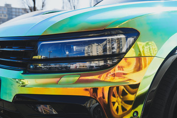 Chameleon holographic colour car. Front view closeup. Modern LED headlights. Car wrapping. Car...