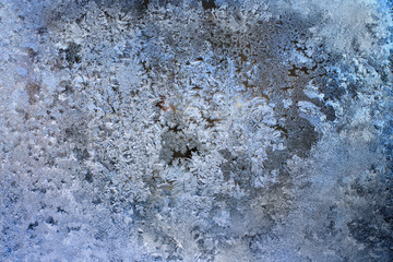 Abstract and fantastic icy patterns on frozen window glass. Hoarfrost effect texture. Blue winter background. Clear frosty ornament on surface. Christmas or winter backdrop. Rime or frost structure