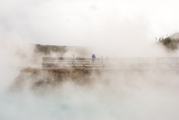Steam and mist from Excelsior Geyser Crater envelop tourists on the boardwalk in Yellowstone National Park