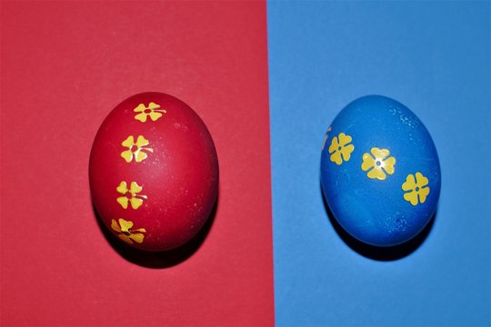 Red and blue Easter eggs decorated with  golden stickers isolated on red and blue background.