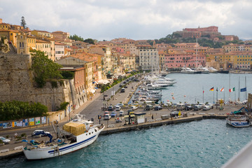 Fototapeta na wymiar Water view of colorful buildings and harbor of Portoferraio, Province of Livorno, on the island of Elba in the Tuscan Archipelago of Italy, Europe, where Napoleon Bonaparte was exiled in 1814