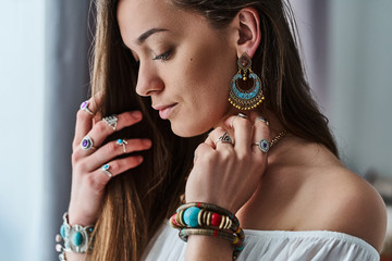 Stylish sensual boho chic woman in white blouse wears big earrings, bracelets and silver rings. Fashionable indian hippie gypsy bohemian outfit with imitation jewelry details - obrazy, fototapety, plakaty
