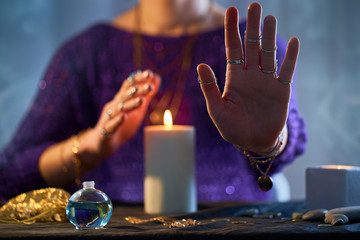 Fortune teller woman using burning candle flame for spell, witchcraft, divination and fortune...