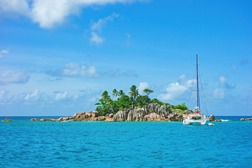 tropical landscape with yacht in the ocean,  catamaran in a bay in the Seychelles
