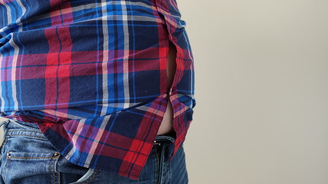 Overweight Man Standing On Left Side Wearing Jeans And Plaid Shirt With Buttons Popping