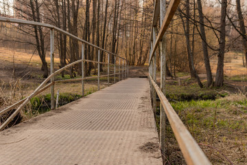 Bridge in the woods, above the river, metal, stands face