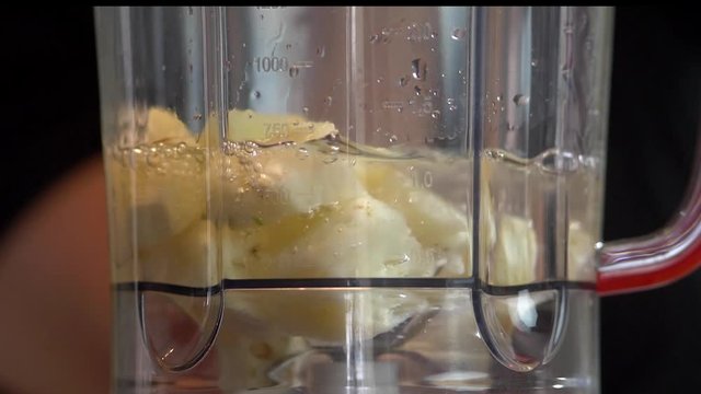 Peda&ccedil;os de abacaxi no liquidificador em slow motion