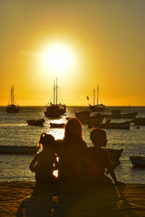 FAMILIA EN ATARDECER CON BARCOS