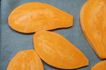 Süßkartoffelscheiben liegen auf einem Backblech 