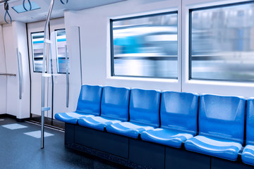 Train station and empty seats commuter with blue color interior inside in the subway train.