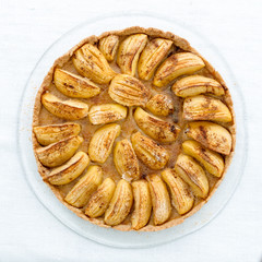 Selbstgemachter Apfelkuchen auf einem gläsernen Kuchenteller