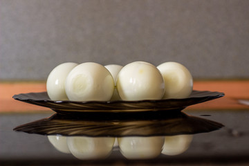 Peeled eggs on a black plate. Hard-boiled eggs. Cooking.