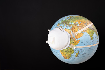 Planet earth with mask. Fight and prevention against coronavirus. COVID-19 prevention, pollution and climate change concept. In the foreground Europe, Africa and Asia. Black background