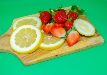 Lemons and strawberries on the wooden cutting board