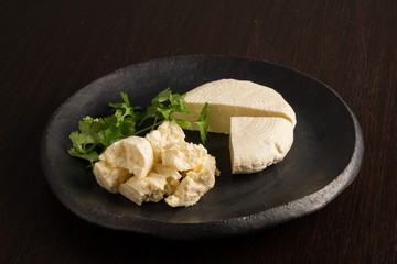 natural homemade cheese with grapes on a dark background
