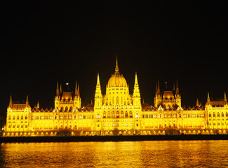 Fototapeta na wymiar View of the Hungarian Parliament Building and the Danube river at night in Budapest, Hungary.