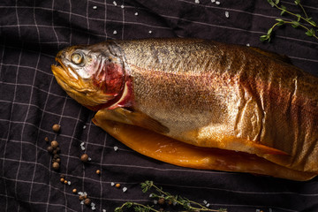 smoked fish with a head on a dark background