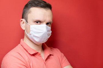 COVID-19 pandemic coronavirus a person wears a protective face mask to protect against the spread of the 2019 coronavirus disease. Portrait of a man with a surgical mask on his face against SARS-cov-2