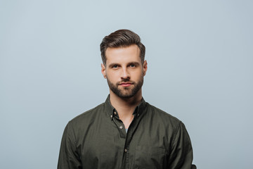 Obraz premium Handsome bearded man looking at camera isolated on grey