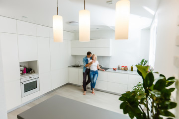 Coronavirus. A couple sitting on a sofa on a quarantine at home Couple at home looking each other, both wear masks because of avoiding contagion. Stay at home. Romantic.