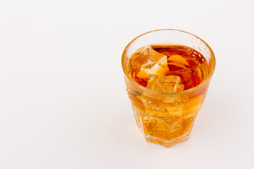 Glass of scotch whiskey and ice over white background.