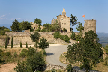 Fototapeta na wymiar Historic castle flying Spanish flag near village of Solsona, Cataluna, Spain