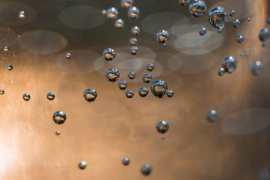 Świetliste pęcherzyki gazu w szklance wody.