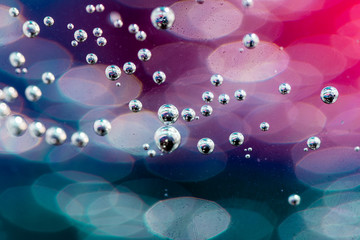 Świetliste pęcherzyki gazu w szklance wody.