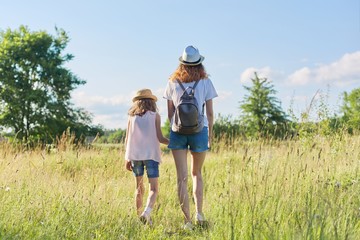 Fototapeta premium Summer vacation, children two girls sisters walking together holding hands