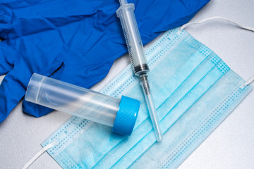 disposable medical mask,syringe, disposable blue glove, test tube for analysis. testing for...