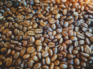 Close up. Roasted brown coffee beans on the table.