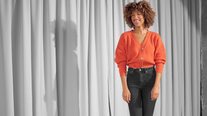 Mixed race black woman with curly hair and natural warm make-up for dark skin have fun with tongue out