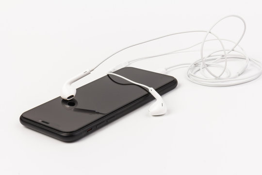 Creative flat lay photo of workspace desk with earphones and mobile phone