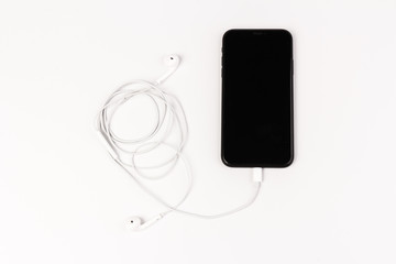 Creative flat lay photo of workspace desk with earphones and mobile phone