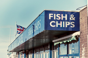 A vintage retro traditional british seaside fish and chips cafe sign and building. English seaside fast food chip shop. lettering and signs. english food restaurant. - obrazy, fototapety, plakaty