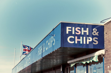 A vintage retro traditional british seaside fish and chips cafe sign and building. English seaside fast food chip shop. lettering and signs. english food restaurant.