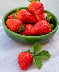 Red ripe strawberries in green bowl