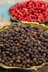 Bowl with dried black and red round peppers condiment