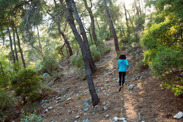 Obraz premium A woman runs along a mountain trail.