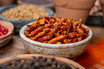 Indian spices collection, dried red hot chili peppers and another spices in clay bowls