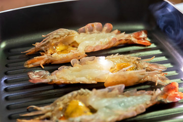 Grilled river prawn cooking on pan.