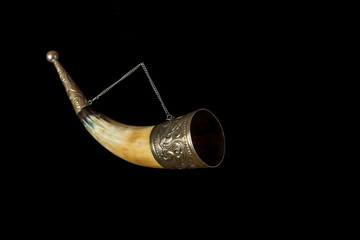 Horn for wine on chain on black background